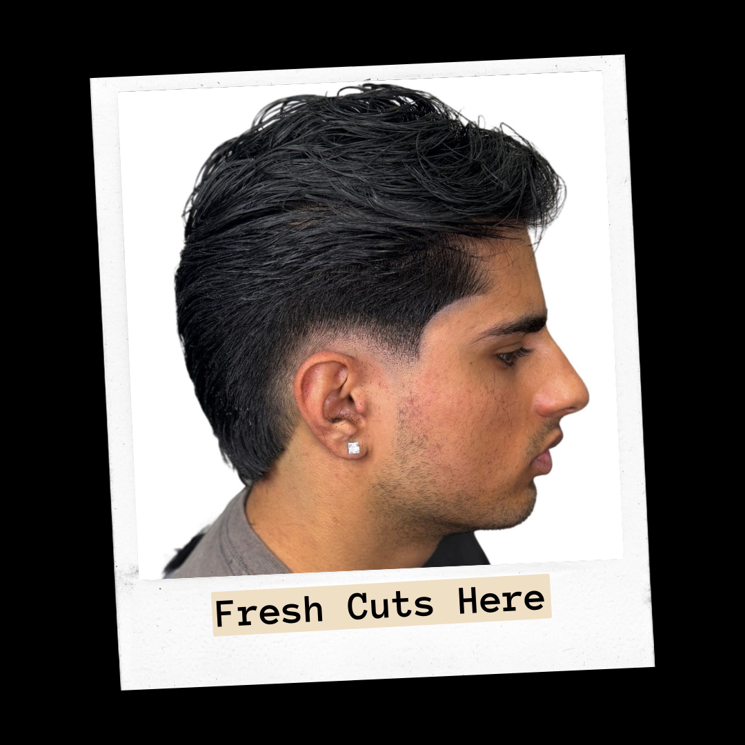 Side profile of a textured swept-back fade with a clean taper on a man wearing a stud earring