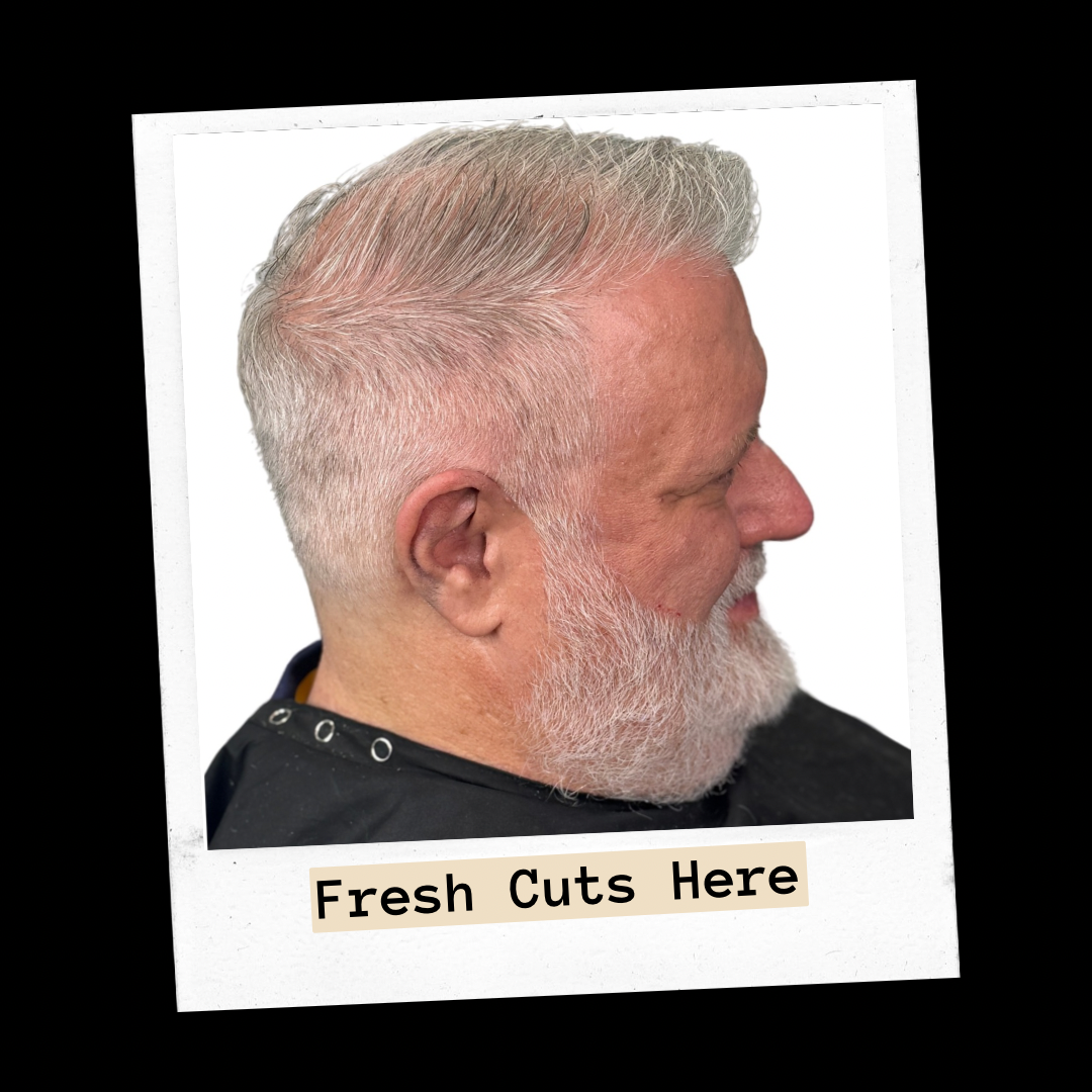 Older client side profile with a neat gray fade and full gray beard